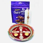Om On Maroon Base Design Puja Thali with Dairy Milk Minis Chocolates and Awesome Rakhis